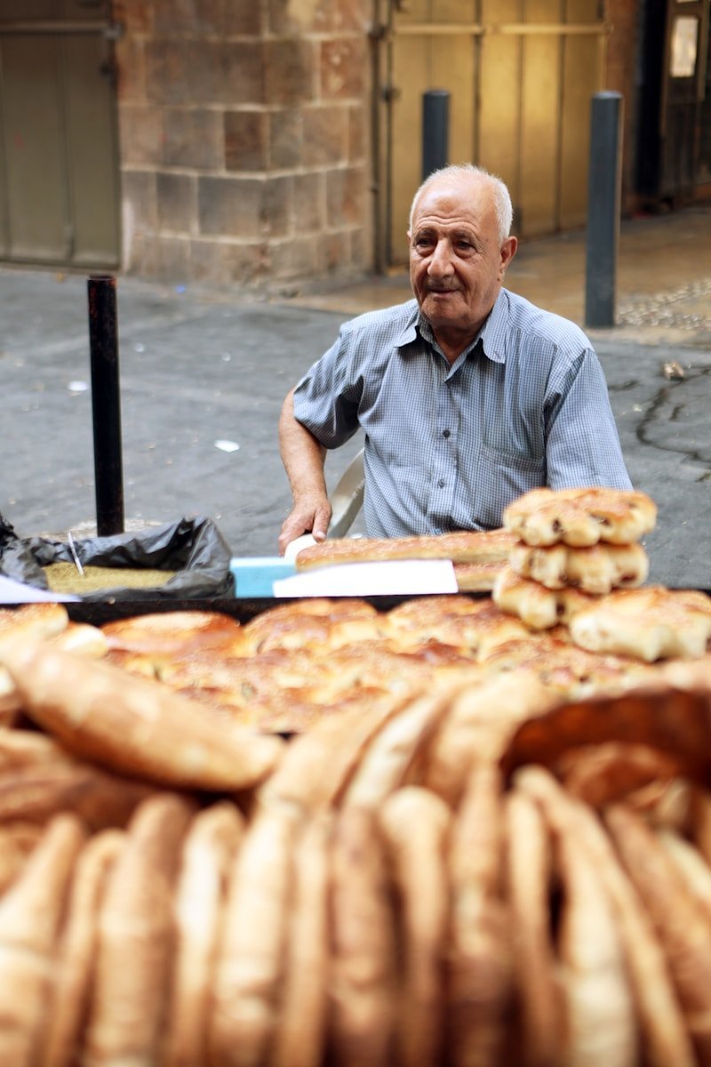 A man sitting at a table with a lot of bread