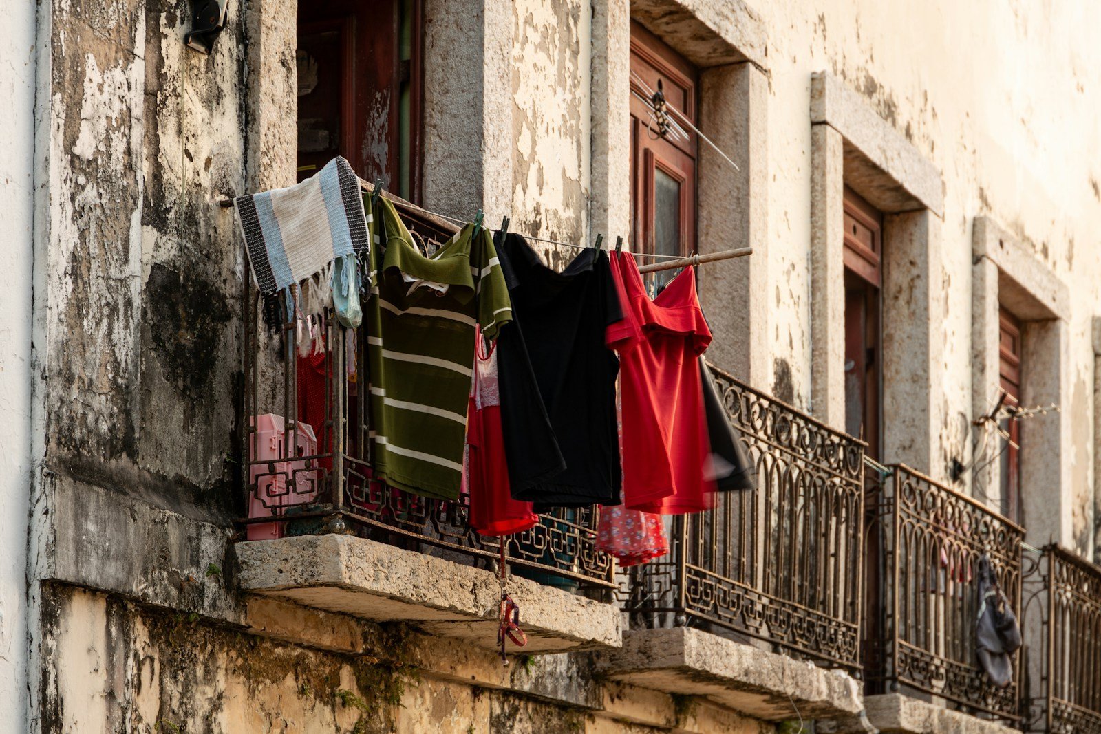 red and green textiles hanging on black steel gate during daytime